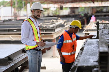 Young engineer is inspecting the work in the factory, the work of the plasterers on the...