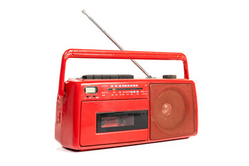 Old fashioned red cassette radio with antenna isolated on white background.