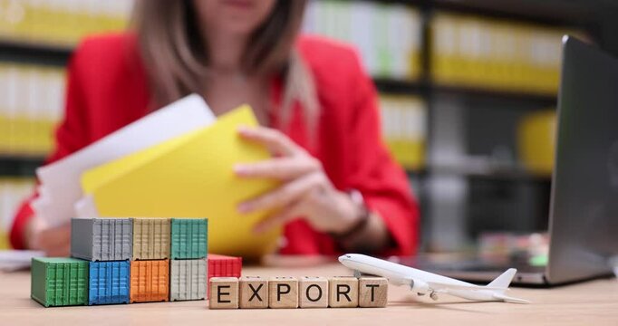 Word Export from cubes against woman checking papers at workplace in office. Logistics manager checks documentation for transporting goods near toy containers