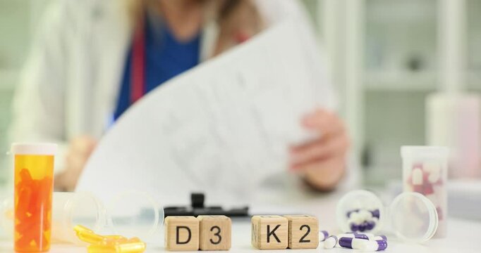 Woman nutritionist prescribes vitamins D3 and K2. Doctor reminds patient to maintain healthy lifestyle with balanced nutrition. Slow motion
