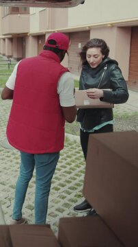 courier African American gives a parce to a woman after signing on delivery device thief steals a box from a car technology order post postal service device sunny beard covered load logistic mailman