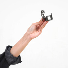 Hand wearing black denim jacket outer holding opened rectangle hair claw accessory isolated on...