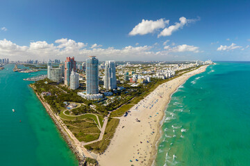South Beach sandy surface with tourists relaxing on hot Florida sun. Tourism infrastructure in...