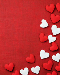 Red and white hearts on textured red background create romantic atmosphere