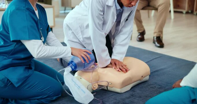 First aid, training and doctor with AED cpr on dummy for cardiac arrest, healthcare practical and emergency rescue. Medical simulation, people and learning chest compression for heart attack survival