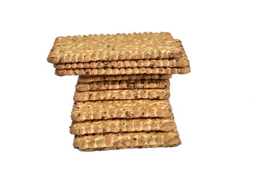 Dry biscuits with sesame seeds lie in a high stack on a white background.