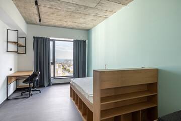 Simple student-style dorm bedroom. Hostel dormitory room. Campus