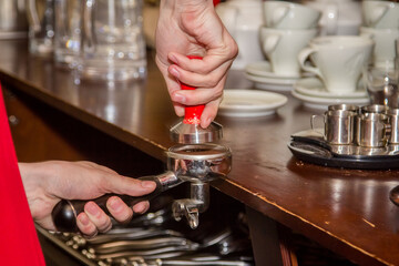 Barista making coffee in a coffee shop, close-up