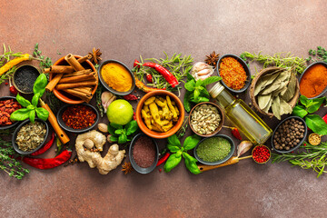 A stunning spread of fresh spices and herbs, meticulously arranged on a deep brown backdrop,...