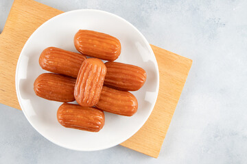 Traditional Turkish dessert tulumba on a plate. Tulumba dessert, fried in oil and soaked in syrup 