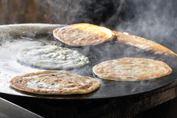 Delicious flatbread cooking on hot surface.