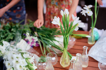 Floral Arrangement Creation on Wooden Table with Fresh White Flowers and Greenery..