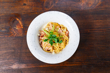 Delicious pasta dish with fresh herbs and cheese on wooden table