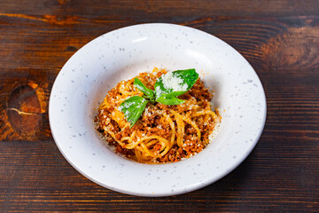 Delicious pasta dish garnished with fresh herbs on wooden table