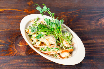 Fresh vegetable salad with creamy dressing and herbs served in a bowl