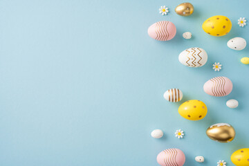 Festive flat lay of colorful painted Easter eggs and small daisies over a soft pastel blue surface, perfect for seasonal greetings and spring celebrations