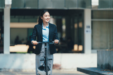 Professional businesswoman riding electric scooter near sleek office building, wearing tailored...
