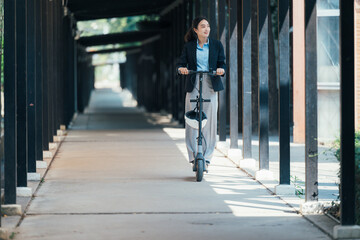 Professional businesswoman balancing helmet, riding electric scooter through urban covered walkway during morning commute © PaeGAG