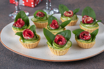 Tartlets in the shape of roses with sausage, cucumber and spinach, festive snack