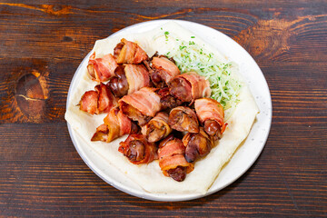 Delicious bacon-wrapped delicacies served with fresh vegetables