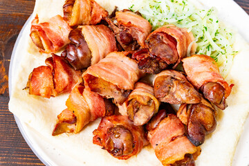 Bacon-wrapped dish with fresh garnishes served at restaurant