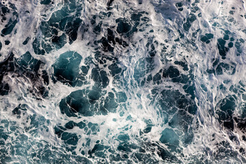 Ocean water background. Top view of breathtaking foamy water. Can be used in covers, packaging, posters, textures, presentations, art, and design projects. Enchanting nature background image.