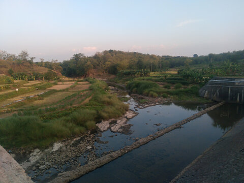 a view of rice fields and a rural river with an upper angel