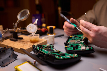 Hands Carefully Repairing a Circuit Board with a Soldering Tool for Electronics Projects