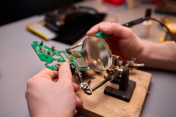 Hands Carefully Repairing a Circuit Board with a Soldering Tool for Electronics Projects