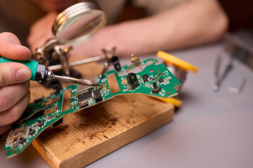 Hands Carefully Repairing a Circuit Board with a Soldering Tool for Electronics Projects