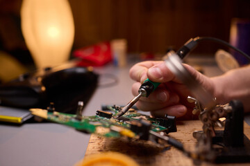 Hands Carefully Repairing a Circuit Board with a Soldering Tool for Electronics Projects