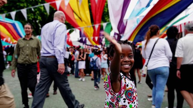 Joyful child enjoys vibrant festival atmosphere at community celebration with colorful flags and lively crowd