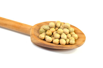 Getrocknete Erbsen auf einem Kochlöffel vor weißem Hintergrund