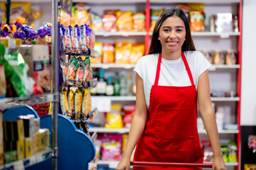 Latina woman, grocery store worker, performs different tasks inside the store. Beautiful portrait of a neighborhood mini supermarket manager.