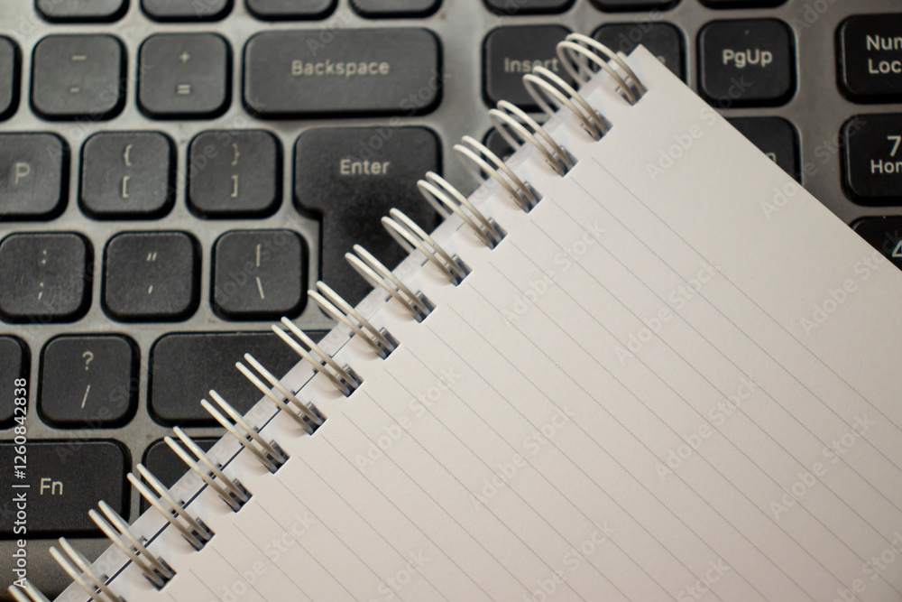 Poster a close-up of a blank notepad resting on a modern keyboard, symbolizing creativity and productivity 