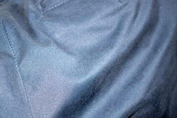 Close-up of smooth dark fabric with a subtle sheen, showcasing intricate texture and folds, perfect...