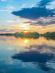Obraz premium Beautiful sunset over a lake with trees in the background