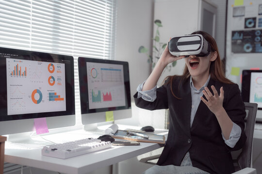 Businesswoman wearing a VR headset immerses in virtual reality for financial data analysis within a modern office, showcasing innovative technology transforming business practices