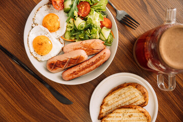 Fried sausages with eggs raspberry tea for breakfast.