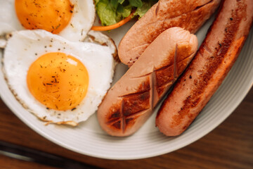 Fried sausages with eggs raspberry tea for breakfast.