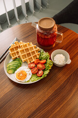 Egg with waffles and raspberry tea for breakfast.