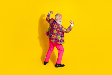 Full length rear portrait of crazy grandfather raise fists shout yeah wear vibrant clothes isolated on yellow color background