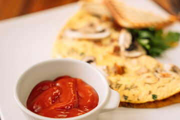 Omelette for breakfast with champignons and sauce.