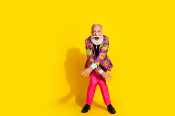 Obraz premium Full size photo of handsome pensioner mister dancing have fun knees wear colorful pink classy garment isolated on yellow color background