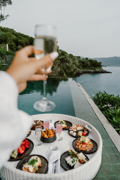 A luxurious oceanfront dining experience featuring a scenic view of the sea, elegant table setup, and gourmet cuisine. Perfect setting for a relaxing and sophisticated meal by the water in Greece