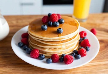 A medium close-up of a beautifully decorated plate of pancakes with syrup and berries, ready for Dad