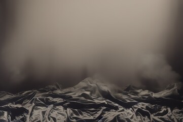 Dramatic landscape of crumpled fabric in mountain-like formations against dark backdrop filled with smoke.

