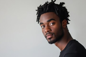 Obraz premium Portrait of a Young Man with Natural Hair Against a Neutral Background