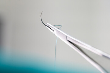 Doctor hand wear sterile gloves and surgery scissor stitching up wound after surgery.Plastic...