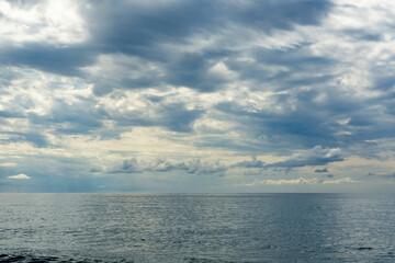 Fototapeta premium A huge cloudy sky filled with thick cumulus clouds creating a dramatic spectacle. Midsummer, Black Sea beach